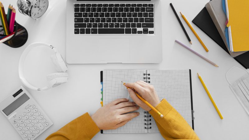 close-up-hand-writing-notebook-top-view